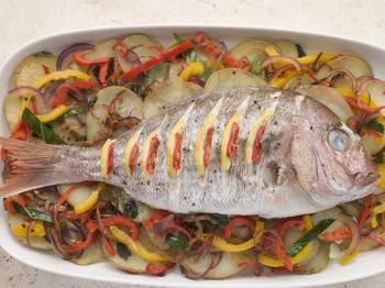 Royalty Free Photo of Whole Roasted Bream with Chili Potatoes and Peppers
