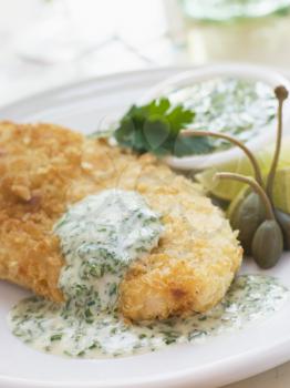Royalty Free Photo of Crumbed Chicken Breast with Green Yoghurt Dressing