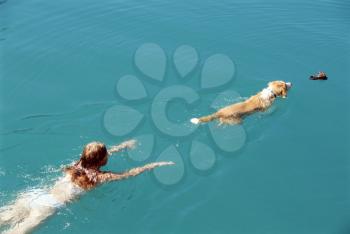 Royalty Free Photo of a Woman and Dog Swimming in a Lake