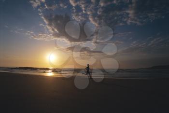 Royalty Free Photo of a Person on the Beach at Sunset