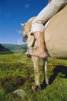 Royalty Free Photo of a Woman Riding a Horse
