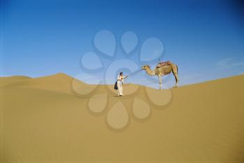 Royalty Free Photo of a Woman With a Camel on the Desert