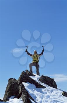 Royalty Free Photo of a Mountaineer Standing Atop a Mountain