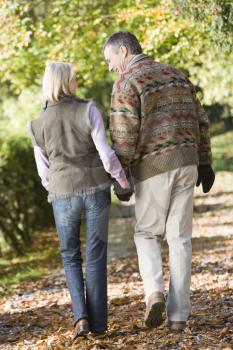 Royalty Free Photo of a Back View of a Couple Holding Hands While Walking in a Park