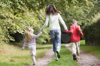 Royalty Free Photo of a Mother and Children Running on a Trail