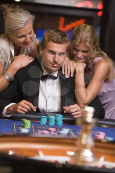 Royalty Free Photo of a Man and Two Women at a Casino