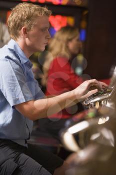 Royalty Free Photo of a Man Playing a Slot Machine