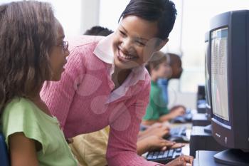 Royalty Free Photo of a Teacher Helping a Student at a Computer