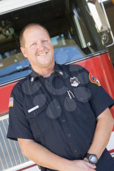Royalty Free Photo of a Firefighter in Front of a Firetruck