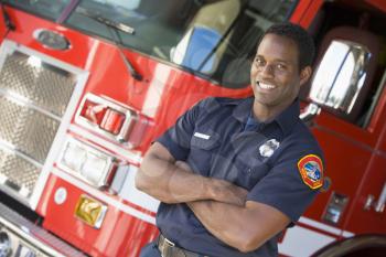 Royalty Free Photo of a Firefighter in Front of a Truck