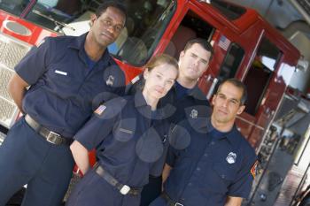 Royalty Free Photo of Four Firefighters Standing in Front of the Truck