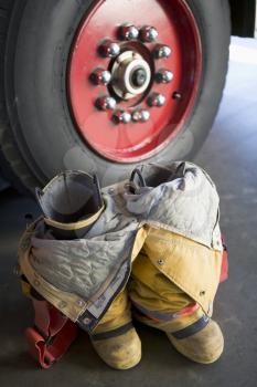 Royalty Free Photo of a Firefighting Suit By the Firetruck Wheel