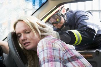 Royalty Free Photo of a Firefighter Helping a Car Crash Victim