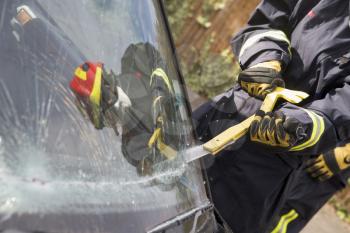 Royalty Free Photo of a Firefighter Cutting a Windshield