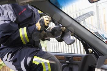 Royalty Free Photo of a Firefighter Cutting Out a Windshield