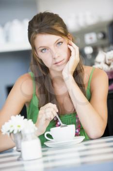 Royalty Free Photo of a Woman Sitting at a Table Drinking Tea