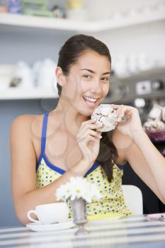 Royalty Free Photo of a Young Woman Eating a Sweet