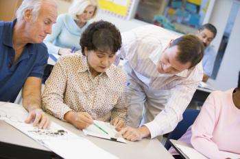 Royalty Free Photo of a Teacher Helping Adult Students