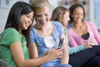 Royalty Free Photo of Girls Looking at a Mobile Phone