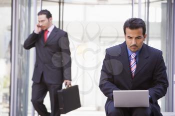 Royalty Free Photo of Businessmen With a Laptop and Cellphone