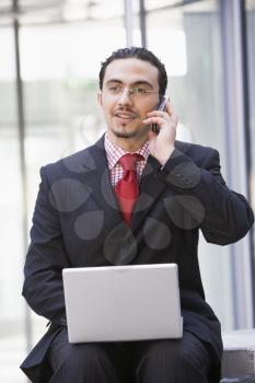Royalty Free Photo of a Man With a Laptop and a Cellphone