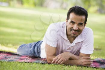 Royalty Free Photo of a Man Lying on a Blanket on a Lawn