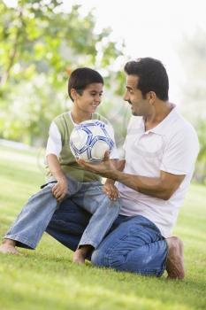 Royalty Free Photo of a Father and Son With a Soccer Ball