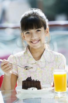 Royalty Free Photo of a Little Girl Having Cake and Juice