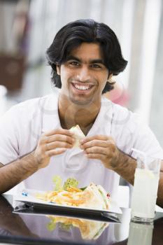 Royalty Free Photo of a Man Eating a Sandwich at a Restaurant