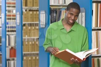 Royalty Free Photo of a Guy in a Library With a Book