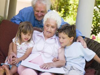 Royalty Free Photo of Grandparents Reading to Their Grandchildren