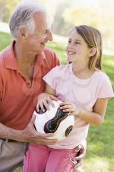 Royalty Free Photo of a Man and His Granddaughter With a Soccer Ball