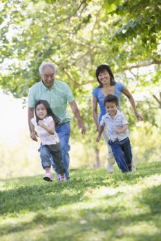 Royalty Free Photo of a Couple Running With Their Grandchildren