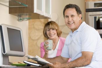 Royalty Free Photo of a Couple in the Kitchen With a Newspaper