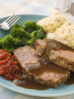 Royalty Free Photo of Meatloaf with Mashed Potato, Broccoli, Tomatoes and Gravy