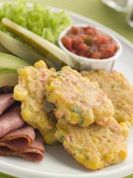 Royalty Free Photo of Sweet Corn Fritters with Salsa Gherkins, Avocado and Pastrami