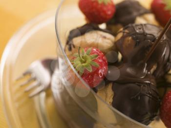 Royalty Free Photo of Chocolate Profiteroles with Strawberries and Chocolate Sauce