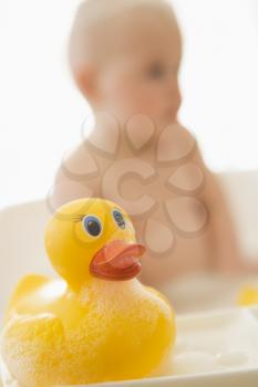 Royalty Free Photo of a Baby in a Bubble Bath With a Toy Duck