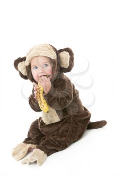 Royalty Free Photo of a Baby in a Monkey Costume Holding a Banana