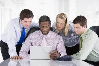 Royalty Free Photo of Four People Around a Laptop