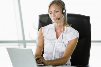 Royalty Free Photo of a Woman in an Office Wearing a Headset