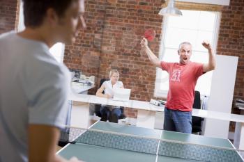 Royalty Free Photo of Two Men Playing Ping Pong in a Home Office