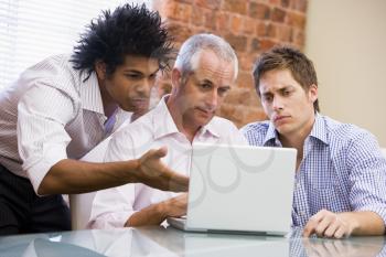 Royalty Free Photo of Three Men Looking at a Laptop