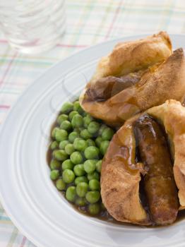 Royalty Free Photo of Individual Toad in the Holes With Gravy and Peas