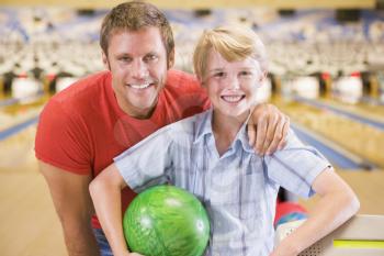 Royalty Free Photo of a Man and Boy at a Bowling Alley