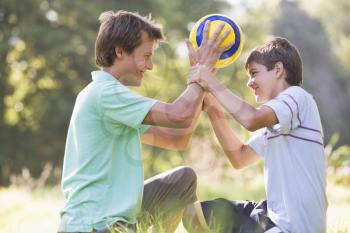 Royalty Free Photo of a Man and Boy With a Soccer Ball