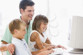 Royalty Free Photo of a Man and Two Children at the Computer