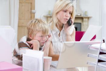 Royalty Free Photo of a Woman on the Phone With Her Son Looking at a Laptop