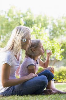Royalty Free Photo of a Mother and Daughter Blowing Bubbles