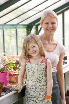 Royalty Free Photo of a Woman and Girl in a Greenhouse